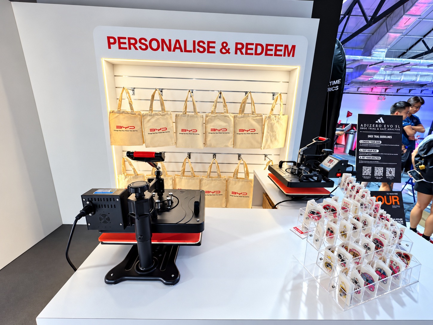 Heat presses and canvas tote bags arranged at a customisation booth