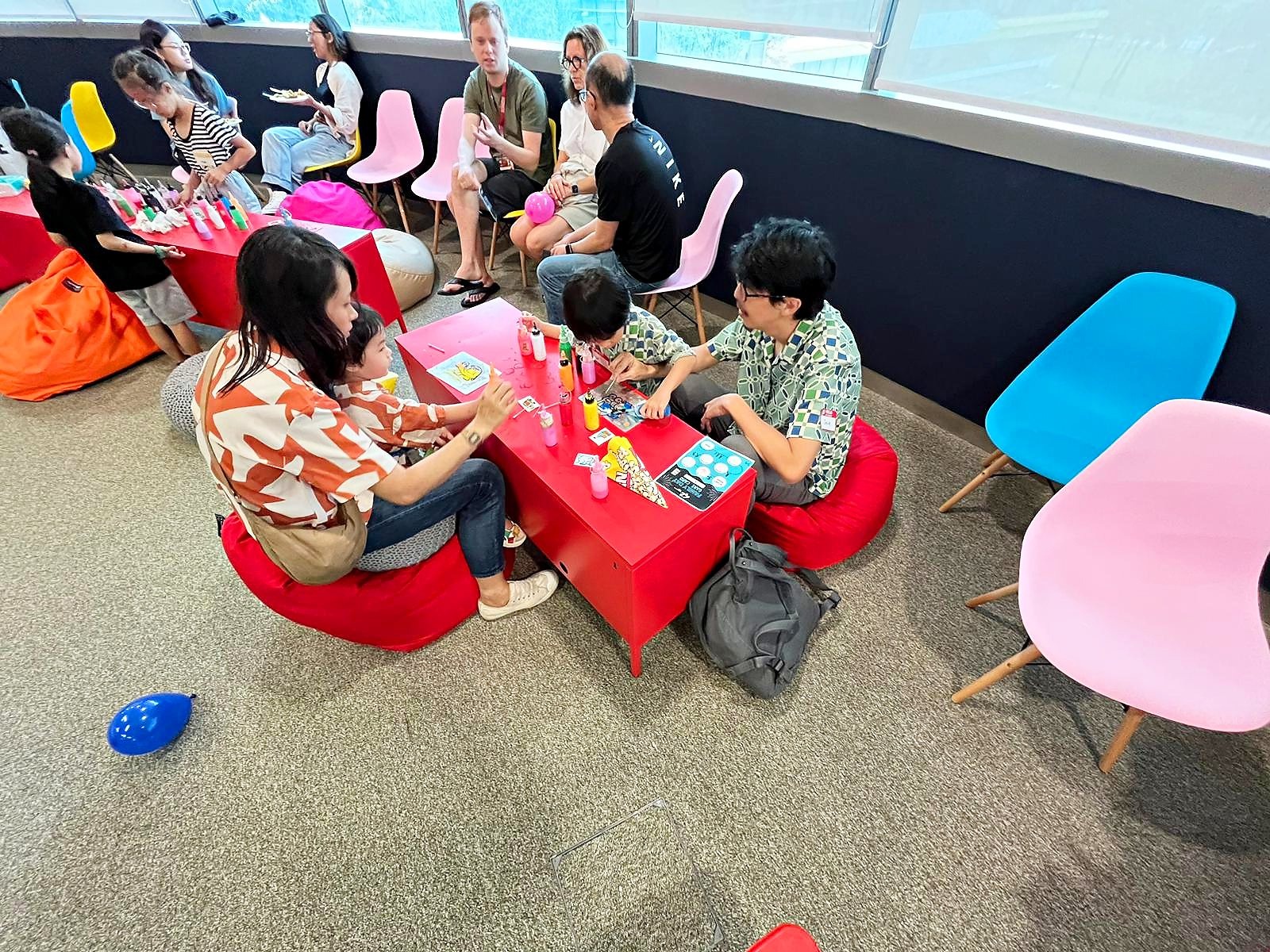 Fringe Activities with families creating window art at a craft table