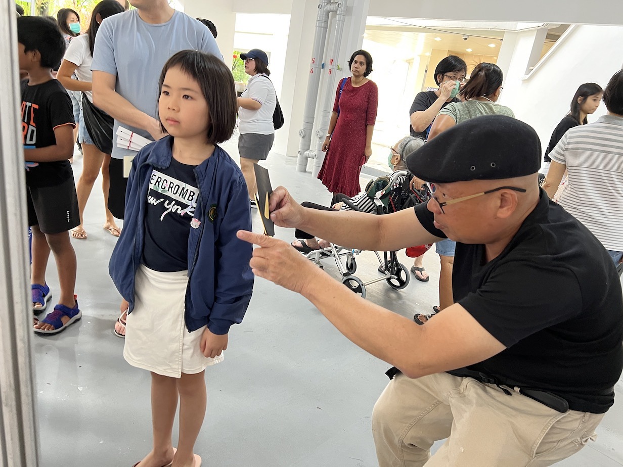 Silhouette artist cutting a child portrait at an event