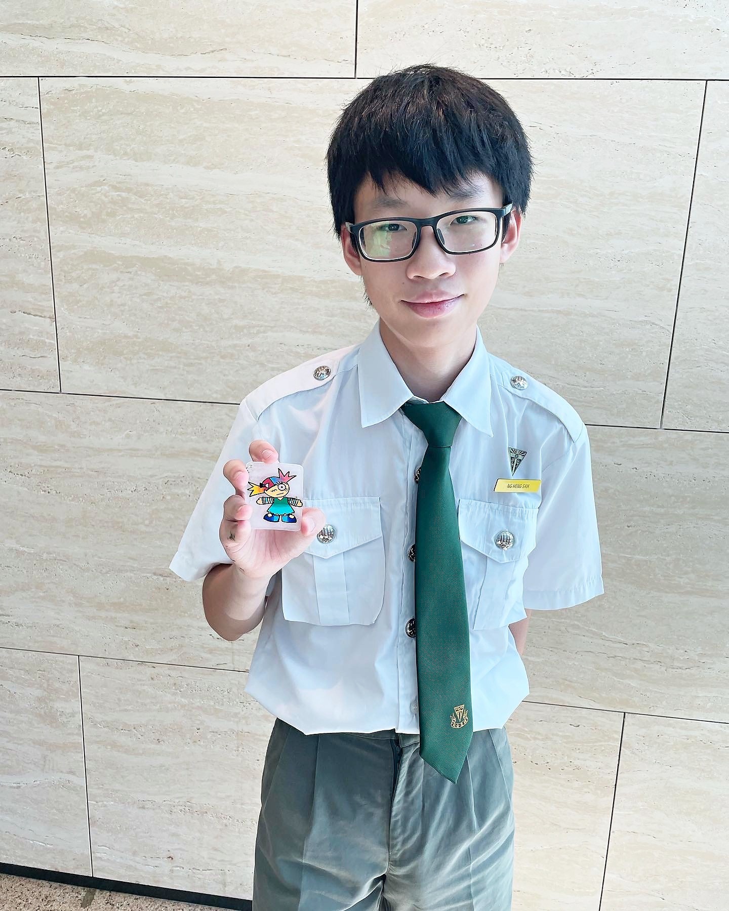 Student holding a completed shrink art keychain